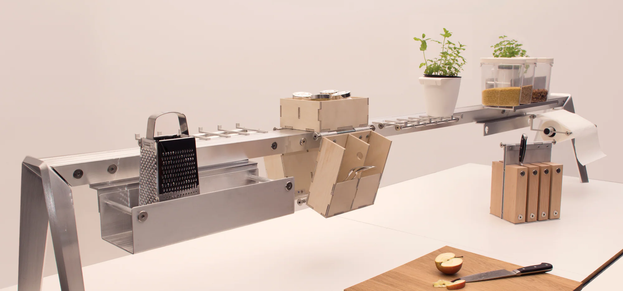Physischer Relisa-Prototyp mit Werkzeugen, Kräutern und Vorratsbehältern über der Arbeitsfläche.